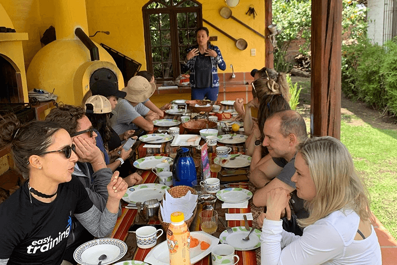 Participantes de taller compartiendo actividades en mesa al aire libre